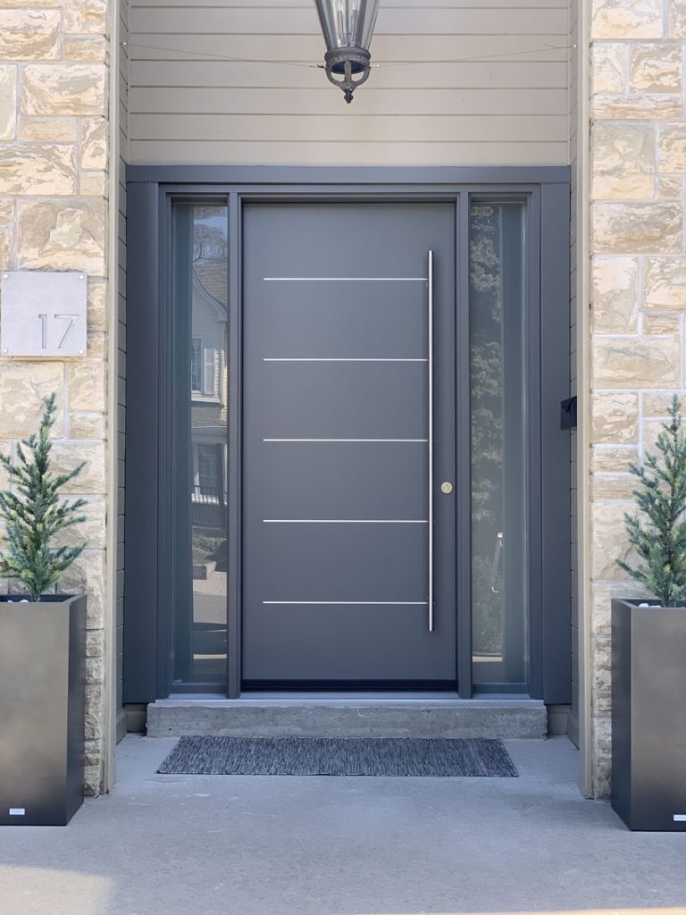 Executive contemporary charcoal fiberglass entry door with horizontal stainless lines, full-height sidelites, and vertical pull bar