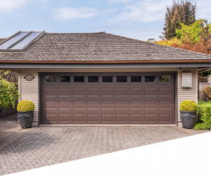 Contemporary dark charcoal insulated garage doors on brick home