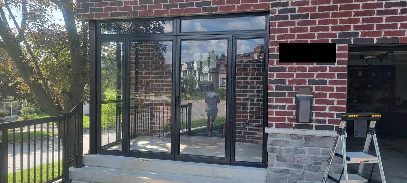 Panoramic tempered glass front foyer winterization enclosure shielding home from winter winds
