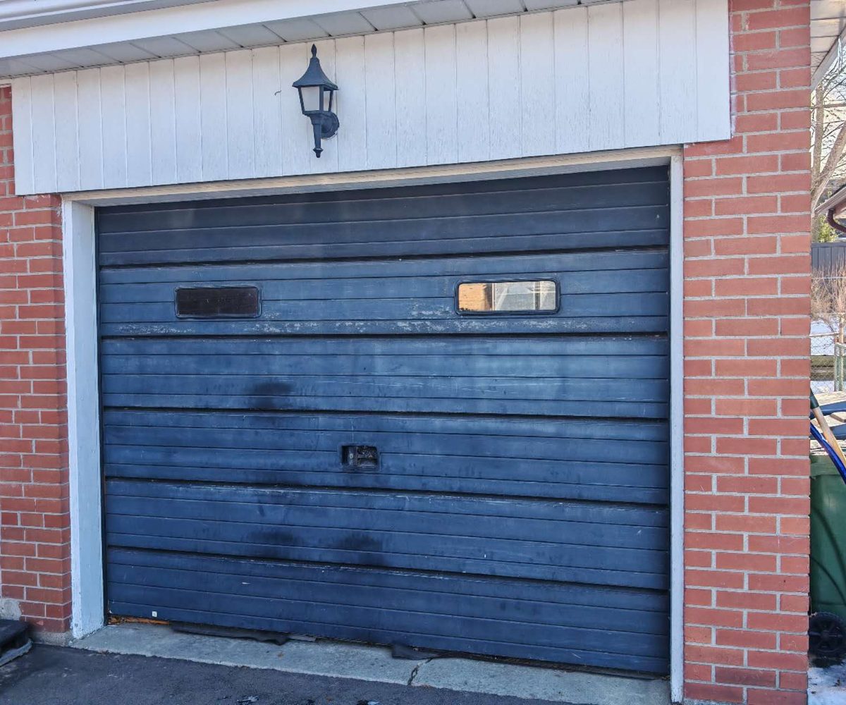Old dark blue ribbed garage door before replacement on a GTA home