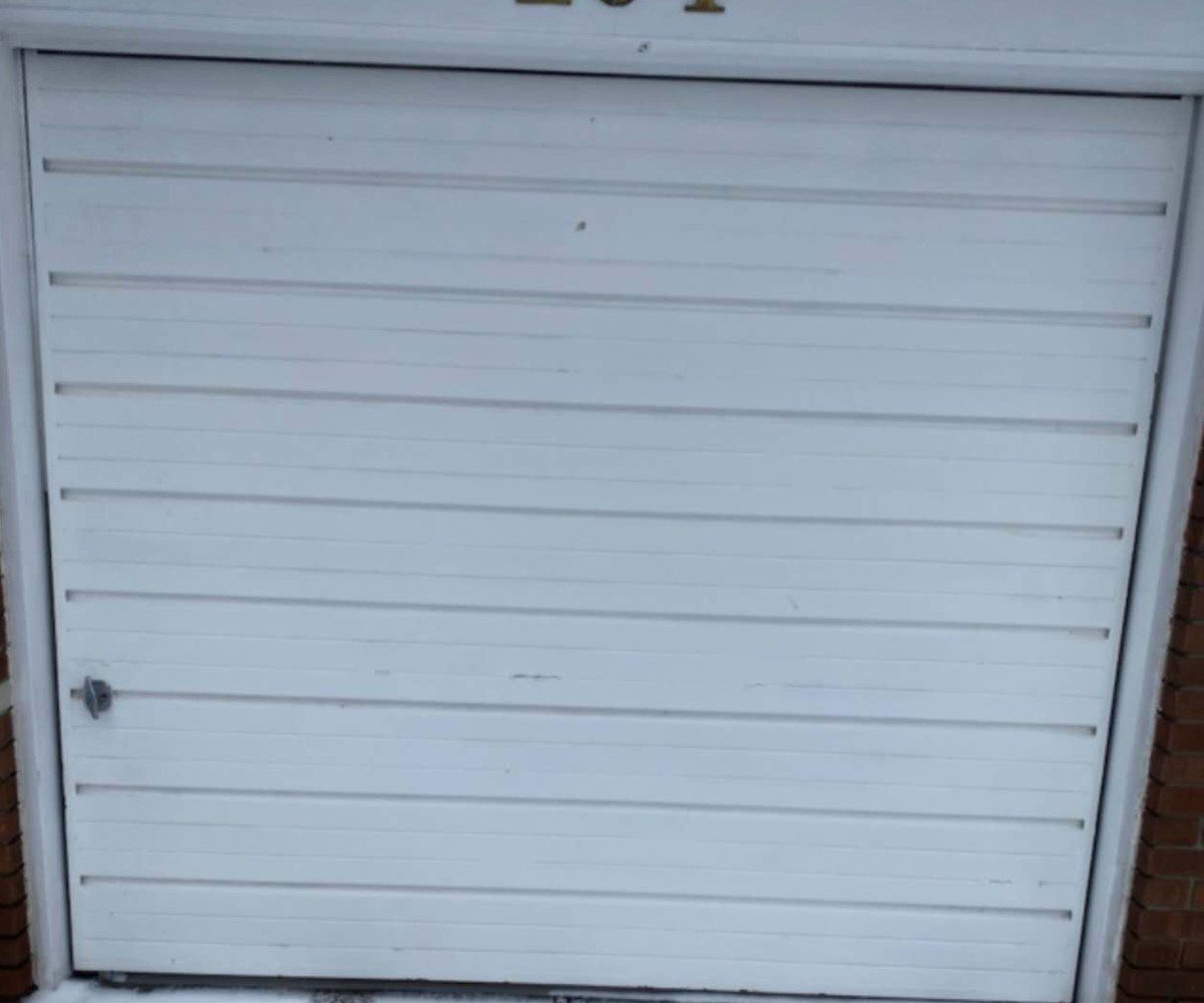 Worn white ribbed garage door before replacement on a Vaughan home